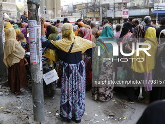 Lower-income people stand in line to buy government-subsidized food in Dhaka, Bangladesh, on November 19, 2024. (