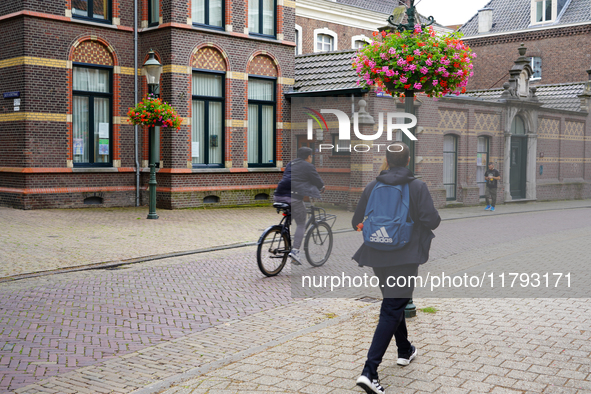 A cyclist and a pedestrian share the historic streets of Venlo, the Netherlands, on July 28, 2023. The scene is a mix of traditional Dutch a...