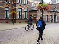 A cyclist and a pedestrian share the historic streets of Venlo, the Netherlands, on July 28, 2023. The scene is a mix of traditional Dutch a...