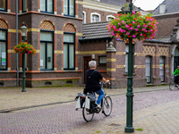 In Venlo, the Netherlands, on July 28, 2023, two women cycle through a scenic street. The cobblestone lane is lined with historic brick buil...