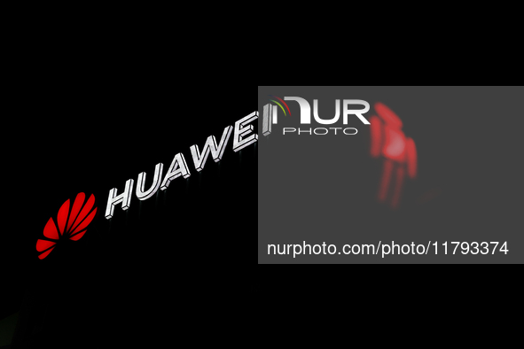 Huawei logo on the building and red traffic light are seen in Warsaw, Poland on November 18, 2024. 