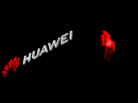 Huawei logo on the building and red traffic light are seen in Warsaw, Poland on November 18, 2024. (