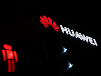 Huawei logo on the building and red traffic light are seen in Warsaw, Poland on November 18, 2024. (