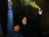 Smoke flares and black confetti are fired during a protest organized on the 1000th day of the war in Ukraine in front of the Embassy of the...