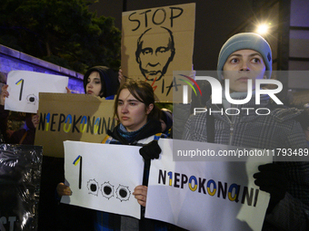 People hold placards and signs that read ''Stop Russia'' and ''Unbeatable'' as they rally on the 1000th day of Russian aggression on Ukraine...