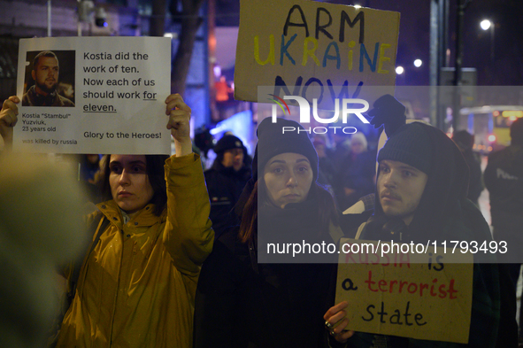 People hold placards and signs that read ''Arm Ukraine Now'' and ''Russia is a terrorist state'' as they rally on the 1000th day of Russian...