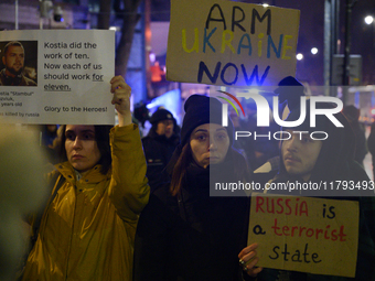 People hold placards and signs that read ''Arm Ukraine Now'' and ''Russia is a terrorist state'' as they rally on the 1000th day of Russian...