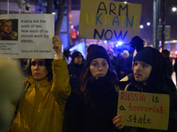 People hold placards and signs that read ''Arm Ukraine Now'' and ''Russia is a terrorist state'' as they rally on the 1000th day of Russian...