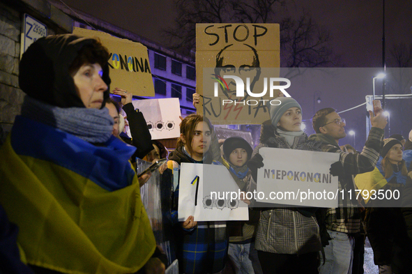 People hold placards and signs that read ''Stop Russia'' and ''Unbeatable'' as they rally on the 1000th day of Russian aggression on Ukraine...