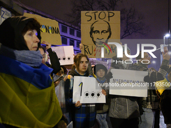 People hold placards and signs that read ''Stop Russia'' and ''Unbeatable'' as they rally on the 1000th day of Russian aggression on Ukraine...