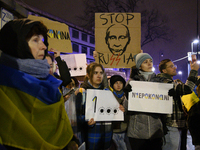 People hold placards and signs that read ''Stop Russia'' and ''Unbeatable'' as they rally on the 1000th day of Russian aggression on Ukraine...