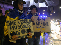 People hold signs that read ''Save Ukrainian Prisoners of War'' and ''Arm Ukraine Now'' as they rally on the 1000th day of Russian aggressio...