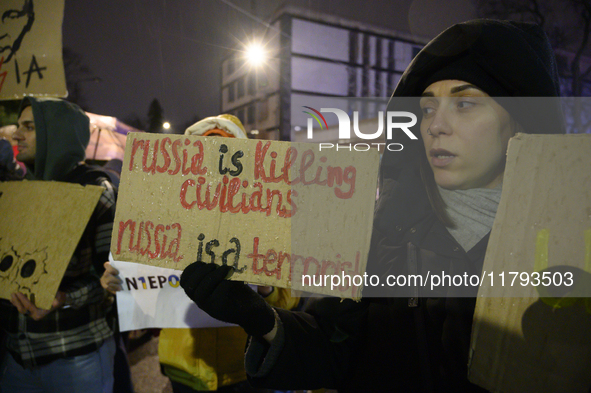 A woman holds a sign that reads ''Russia is killing civilians Russia is a terrorist'' as she takes part in the 1000th day of Russian aggress...