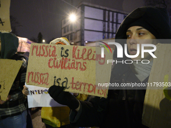 A woman holds a sign that reads ''Russia is killing civilians Russia is a terrorist'' as she takes part in the 1000th day of Russian aggress...