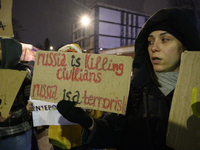 A woman holds a sign that reads ''Russia is killing civilians Russia is a terrorist'' as she takes part in the 1000th day of Russian aggress...