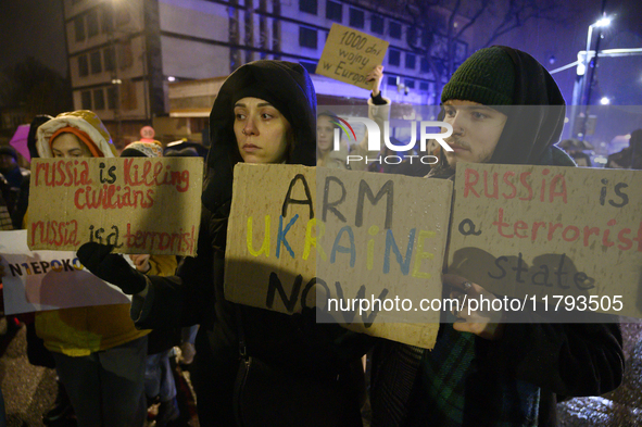 People hold placards and signs that read ''Arm Ukraine Now'' and ''Russia is a terrorist state'' as they rally on the 1000th day of Russian...