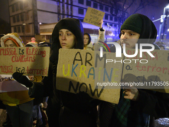 People hold placards and signs that read ''Arm Ukraine Now'' and ''Russia is a terrorist state'' as they rally on the 1000th day of Russian...