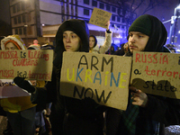 People hold placards and signs that read ''Arm Ukraine Now'' and ''Russia is a terrorist state'' as they rally on the 1000th day of Russian...