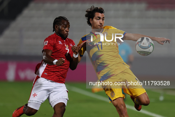 In Ta' Qali, Malta, on November 19, 2024, Joan Cervos of Andorra is closely followed by Joseph Mbong of Malta during the UEFA Nations League...