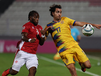 In Ta' Qali, Malta, on November 19, 2024, Joan Cervos of Andorra is closely followed by Joseph Mbong of Malta during the UEFA Nations League...