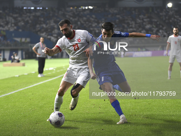 Mohammad Abdullah of Kuwait competes against Ehsan Haddad of Jordan during the AFC Asian Qualifiers Road to 26 match between Kuwait and Jord...