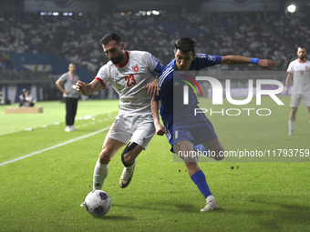 Mohammad Abdullah of Kuwait competes against Ehsan Haddad of Jordan during the AFC Asian Qualifiers Road to 26 match between Kuwait and Jord...