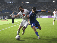 Mohammad Abdullah of Kuwait competes against Ehsan Haddad of Jordan during the AFC Asian Qualifiers Road to 26 match between Kuwait and Jord...