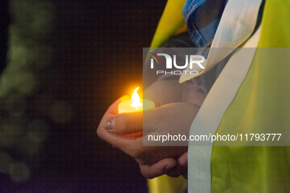 A protester holds a candlelight as two hundred people take part in a demonstration to mark 1000 days since the full-scale war between Ukrain...