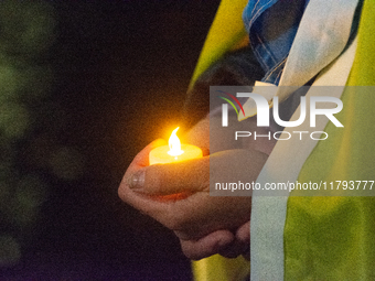 A protester holds a candlelight as two hundred people take part in a demonstration to mark 1000 days since the full-scale war between Ukrain...