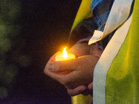 A protester holds a candlelight as two hundred people take part in a demonstration to mark 1000 days since the full-scale war between Ukrain...