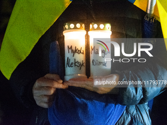 A protester holds a candlelight with victims' names as two hundred people take part in a demonstration to mark 1,000 days since the full-sca...