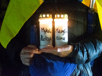 A protester holds a candlelight with victims' names as two hundred people take part in a demonstration to mark 1,000 days since the full-sca...