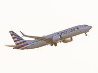 American Airlines Boeing 737 MAX 8 passenger aircraft spotted during takeoff and flying in front of the airport terminal, air traffic contro...