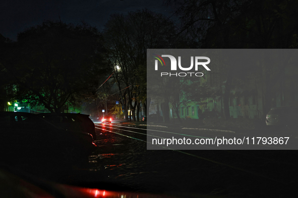 Car headlights flash on the city street during a power outage in Odesa, Ukraine, on November 18, 2024. 