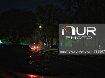 Car headlights flash on the city street during a power outage in Odesa, Ukraine, on November 18, 2024. (