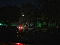 Car headlights flash on the city street during a power outage in Odesa, Ukraine, on November 18, 2024. (