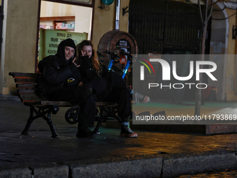 Local citizens sit on a bench during a power outage in Odesa, Ukraine, on November 18, 2024. NO USE RUSSIA. NO USE BELARUS. (