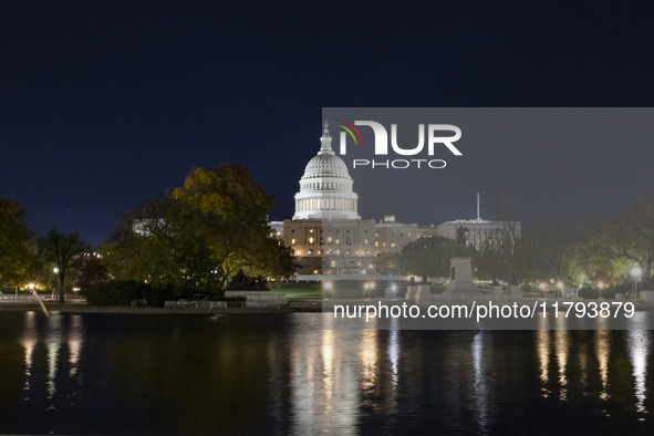 Night view with dark sky of the illuminated US Capitol reflecting on the pool water surface. The Capitol is the seat of the United States Co...