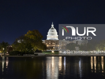 Night view with dark sky of the illuminated US Capitol reflecting on the pool water surface. The Capitol is the seat of the United States Co...