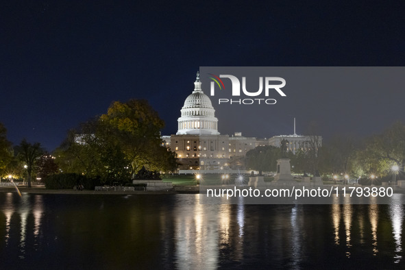 Night view with dark sky of the illuminated US Capitol reflecting on the pool water surface. The Capitol is the seat of the United States Co...