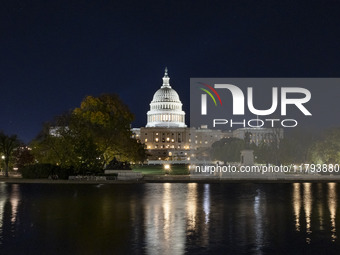 Night view with dark sky of the illuminated US Capitol reflecting on the pool water surface. The Capitol is the seat of the United States Co...