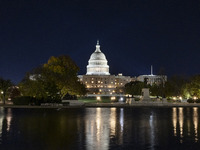 Night view with dark sky of the illuminated US Capitol reflecting on the pool water surface. The Capitol is the seat of the United States Co...