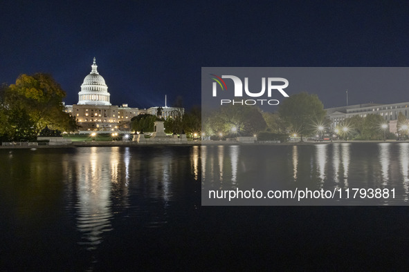 Night view with dark sky of the illuminated US Capitol reflecting on the pool water surface. The Capitol is the seat of the United States Co...