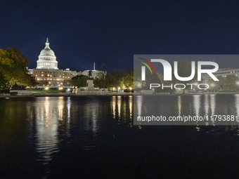 Night view with dark sky of the illuminated US Capitol reflecting on the pool water surface. The Capitol is the seat of the United States Co...