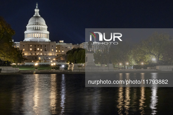 Night view with dark sky of the illuminated US Capitol reflecting on the pool water surface. The Capitol is the seat of the United States Co...