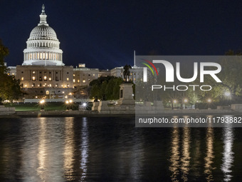 Night view with dark sky of the illuminated US Capitol reflecting on the pool water surface. The Capitol is the seat of the United States Co...