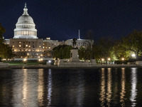 Night view with dark sky of the illuminated US Capitol reflecting on the pool water surface. The Capitol is the seat of the United States Co...