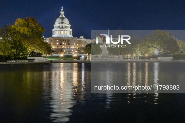 Night view with dark sky of the illuminated US Capitol reflecting on the pool water surface. The Capitol is the seat of the United States Co...