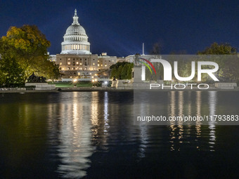 Night view with dark sky of the illuminated US Capitol reflecting on the pool water surface. The Capitol is the seat of the United States Co...