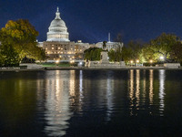 Night view with dark sky of the illuminated US Capitol reflecting on the pool water surface. The Capitol is the seat of the United States Co...